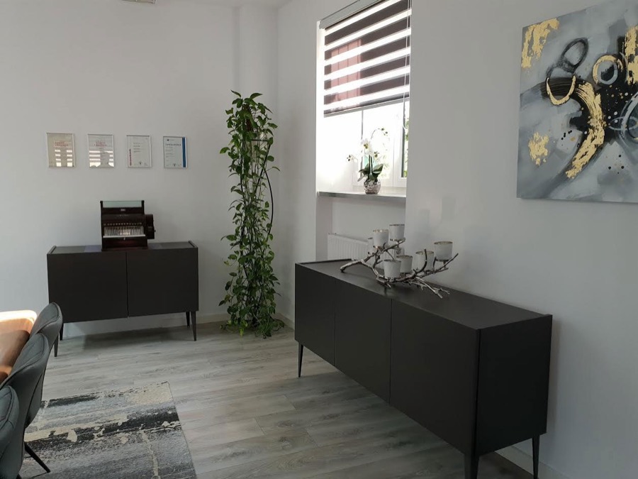 Ausstellungsraum von Kassen Maier Electronics mit Registrierkasse, Pflanze und Sitzgelegenheit